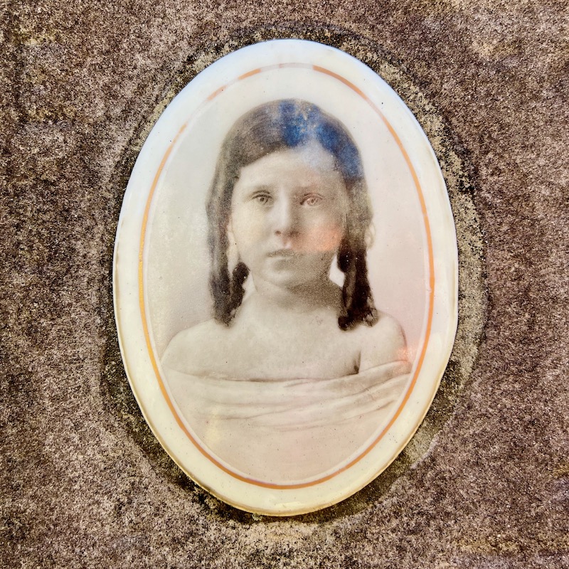 ceramic photograph of young girl inset in gravestone