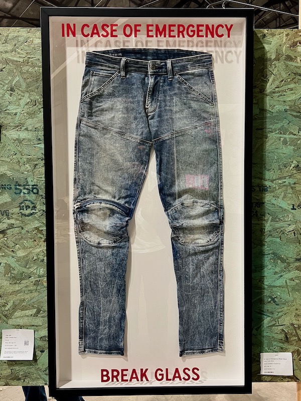 artwork of blue jeans under glass with message "In case of emergency, break glass"