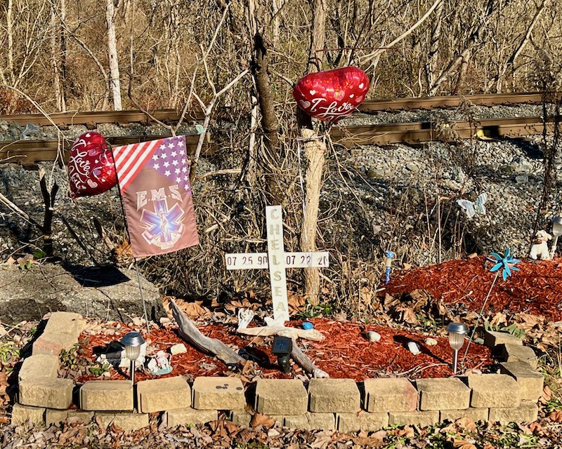 roadside memorial with heart balloons and landscaping bricks