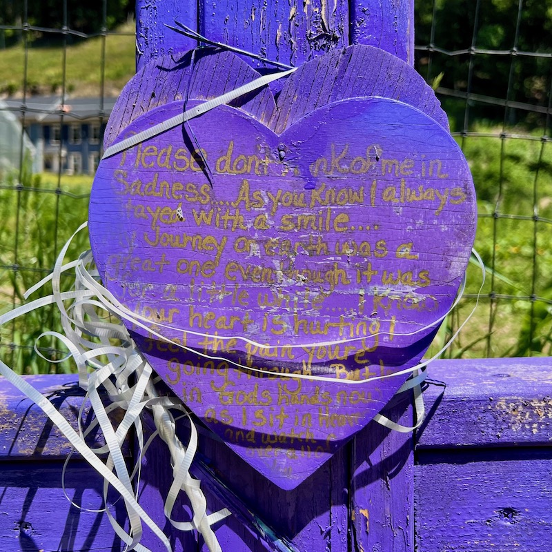 detail from roadside cross of hearts with hard-to-read message