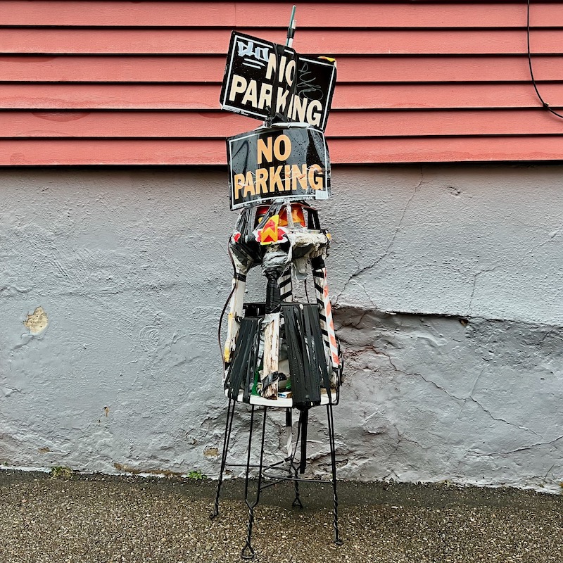 custom built parking spot holder created from stools and "No Parking" signs