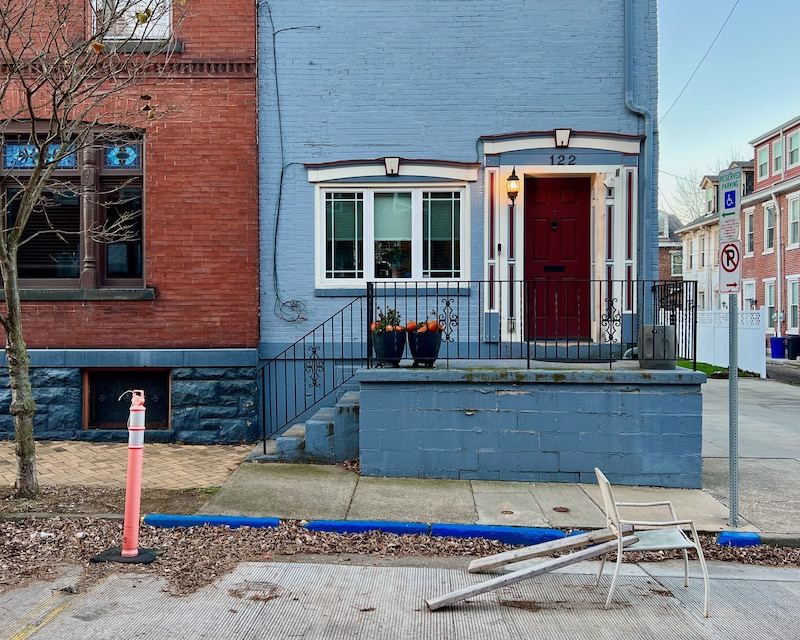 chair and traffic bollard left in front of row houses