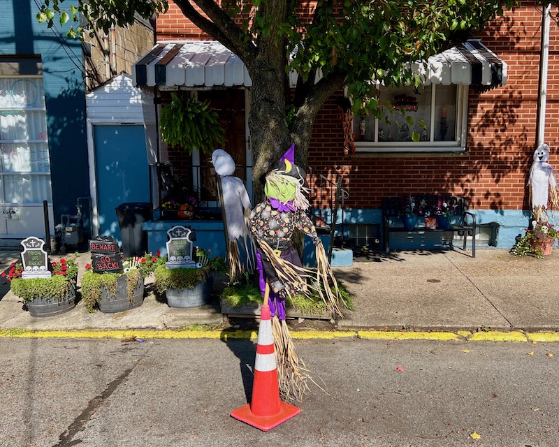 traffic cone with Halloween decoration in front of row house