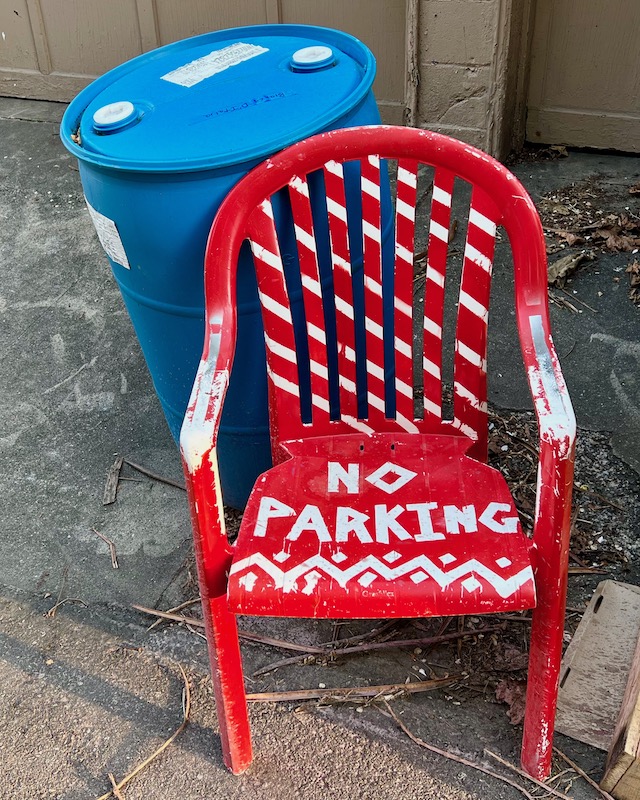 chair painted with "No Parking" message