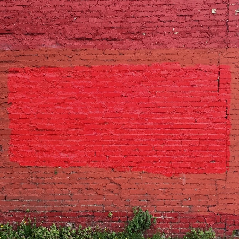 brick wall painted in multiple shades of red