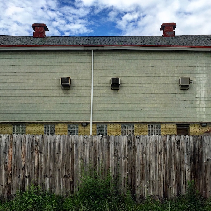 large tiled building with wooden fence
