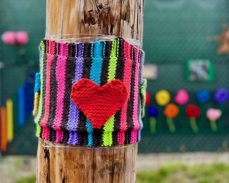 utility pole wrapped in knitted decoration with heart