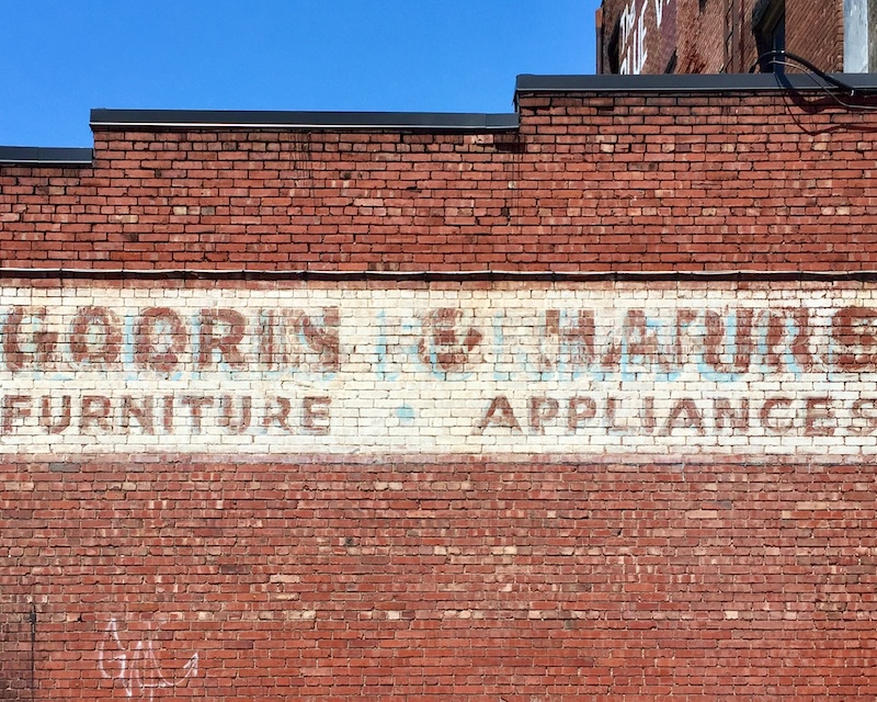 hand-painted sign for furniture store painted on brick wall