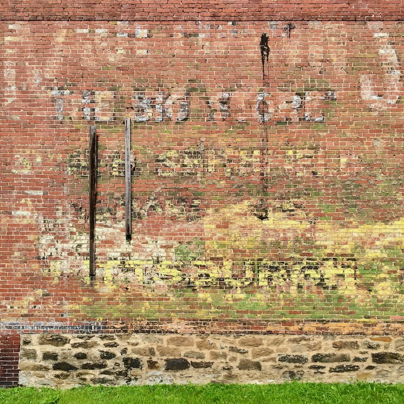 faded hand-painted sign for Kaufmann's Department Store painted on brick wall