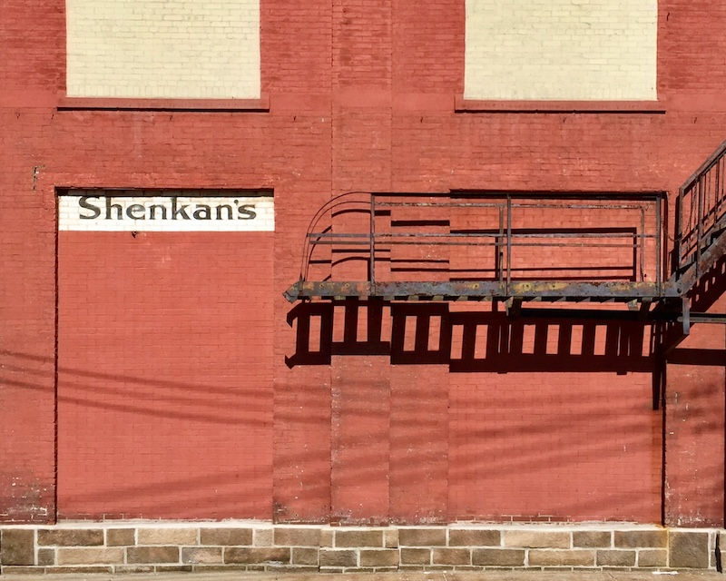 faded hand-painted sign for department store painted on brick wall