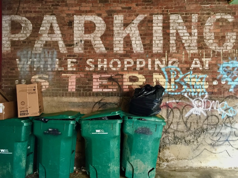 faded hand-painted sign for department store painted on brick wall