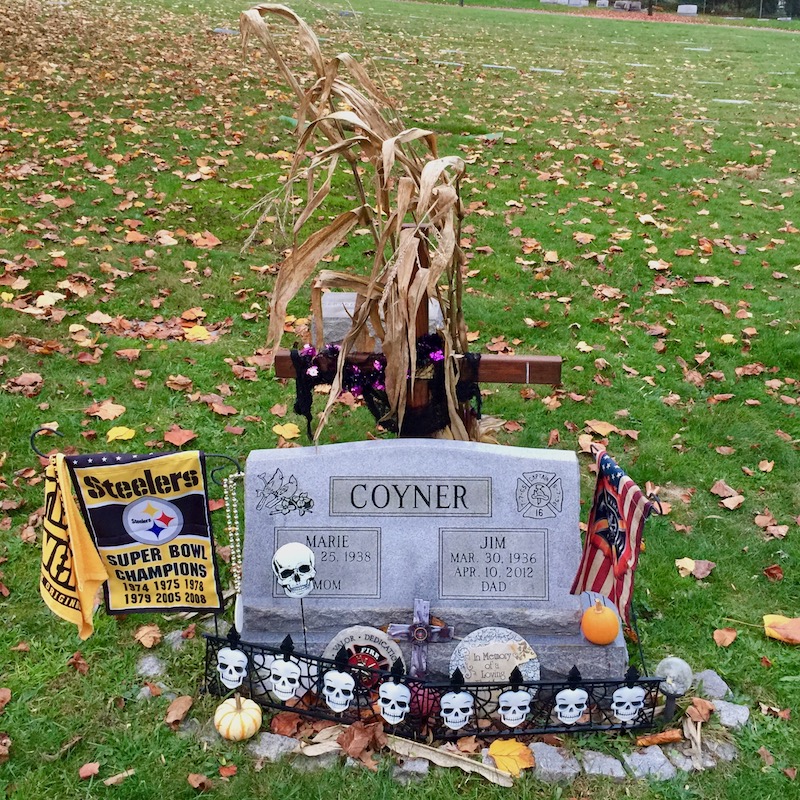 grave marker decorated with Pittsburgh Steelers "terrible towel" and team flag