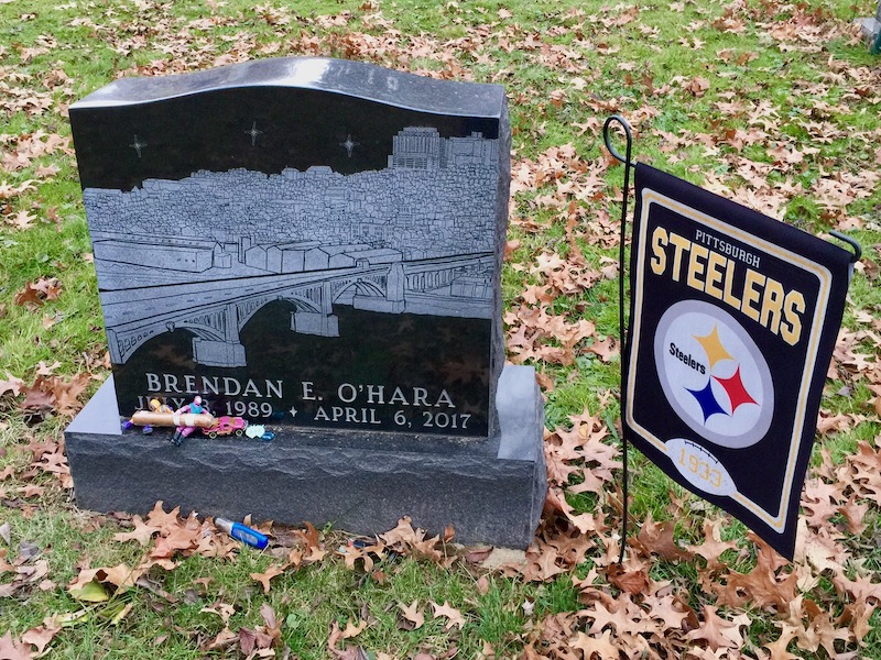 grave marker decorated with Pittsburgh Steelers flag