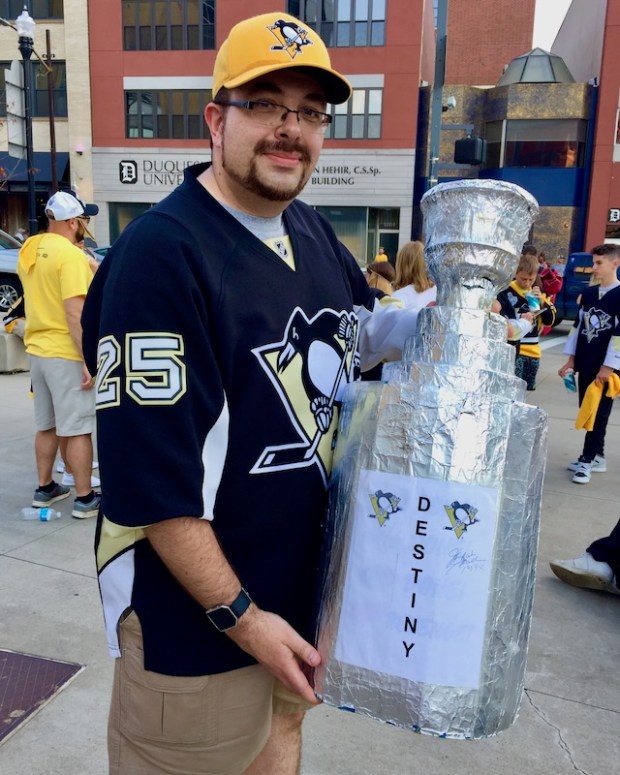 Man with homemade model of the Stanley Cup with sign reading "Destiny"