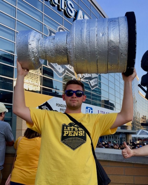 Man holding homemade model of the Stanley Cup outside PPG Paints Arena